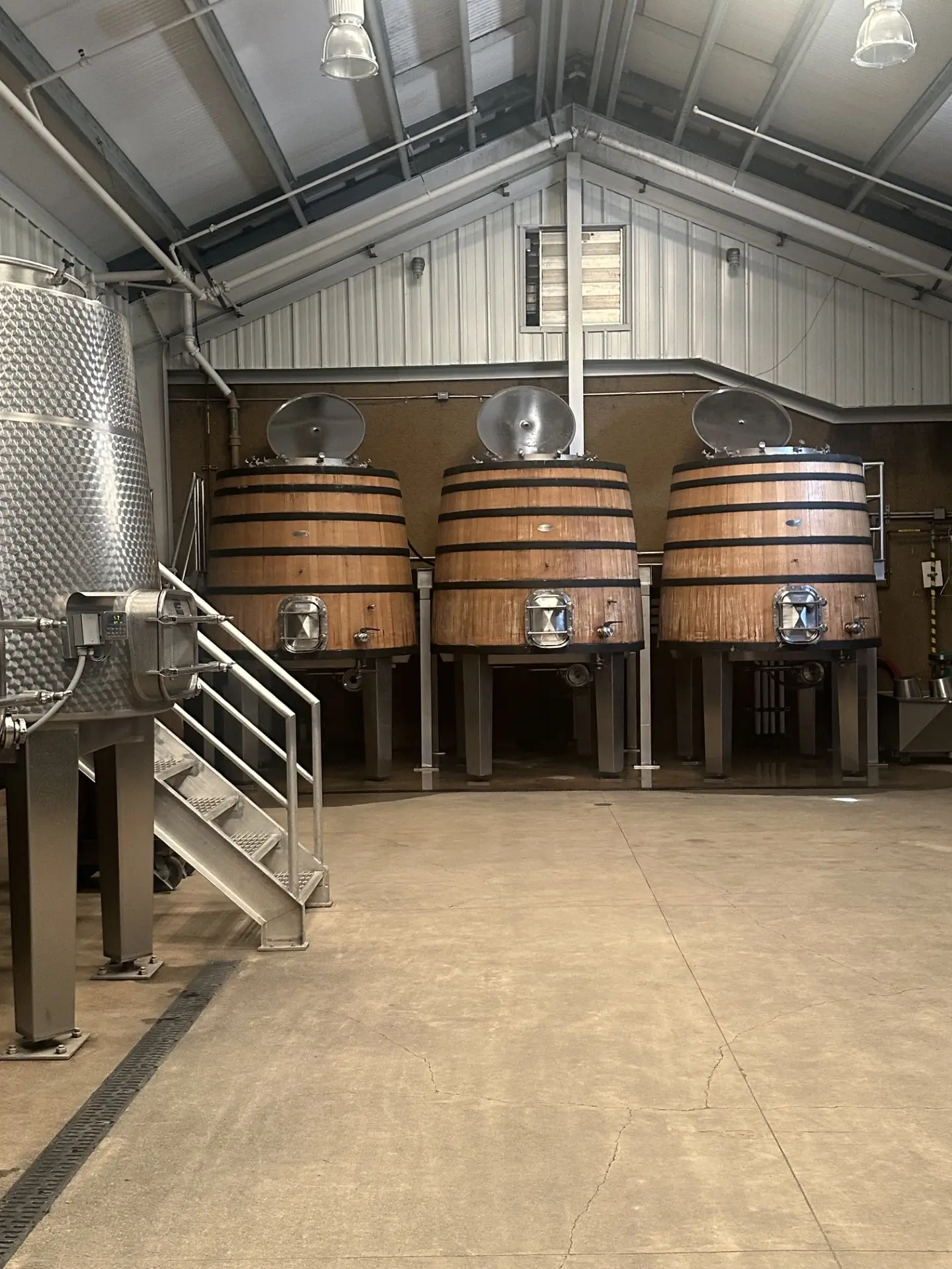 Oak fermentation barrels lined up in the Ninth Acre cellar